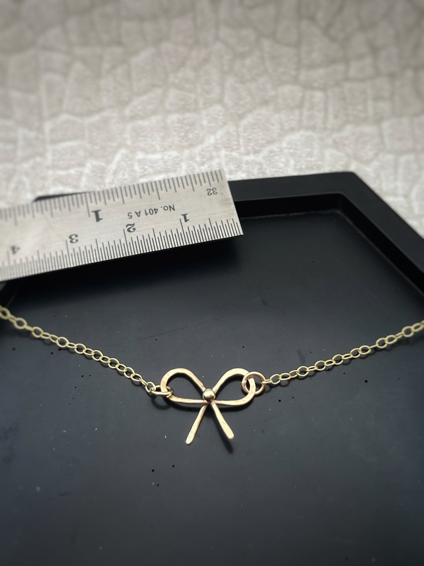 Solid 9ct solid gold bow necklace, a handmade hammered textured ribbon style bow